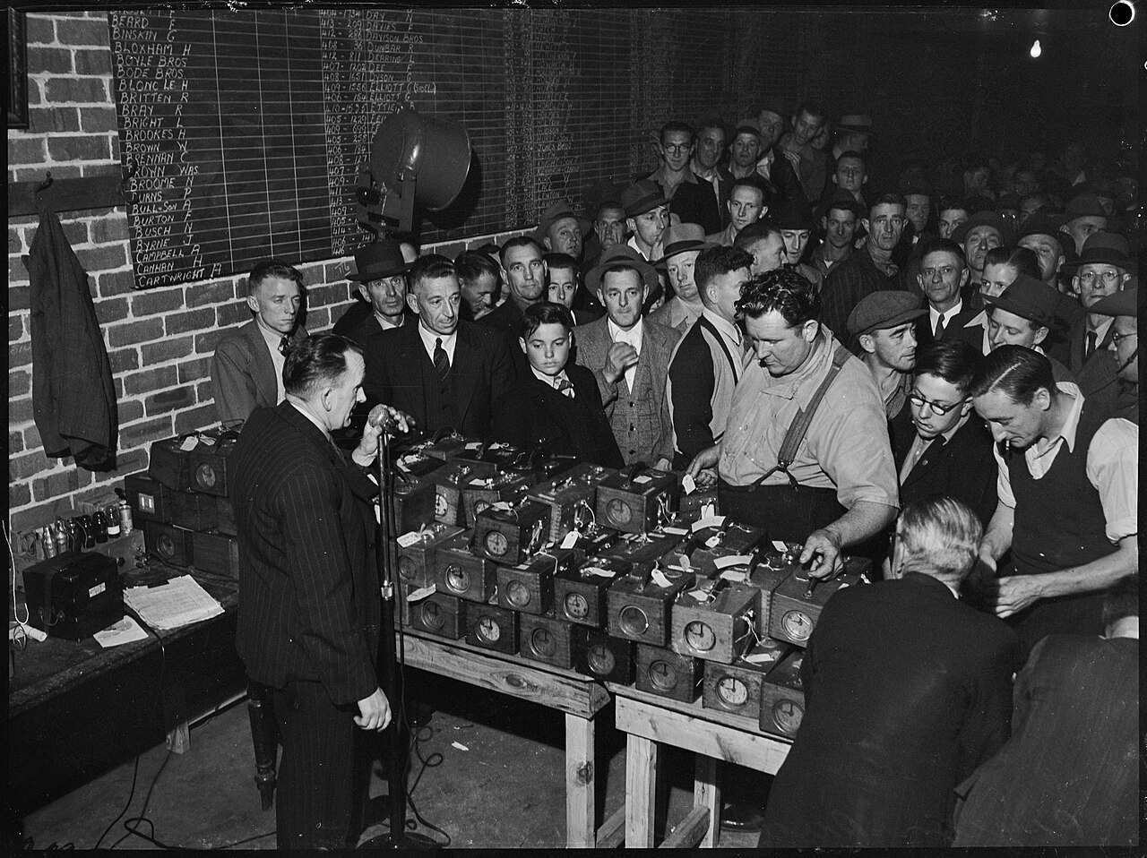 Fanciers gathered around their timing clocks after a race, 1945